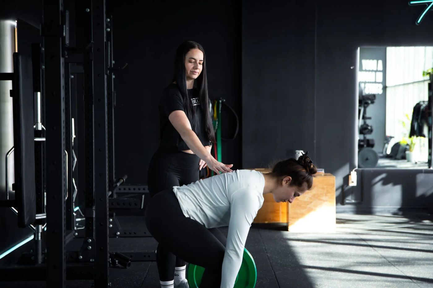 An Inertia coach guiding a client's hip hinge