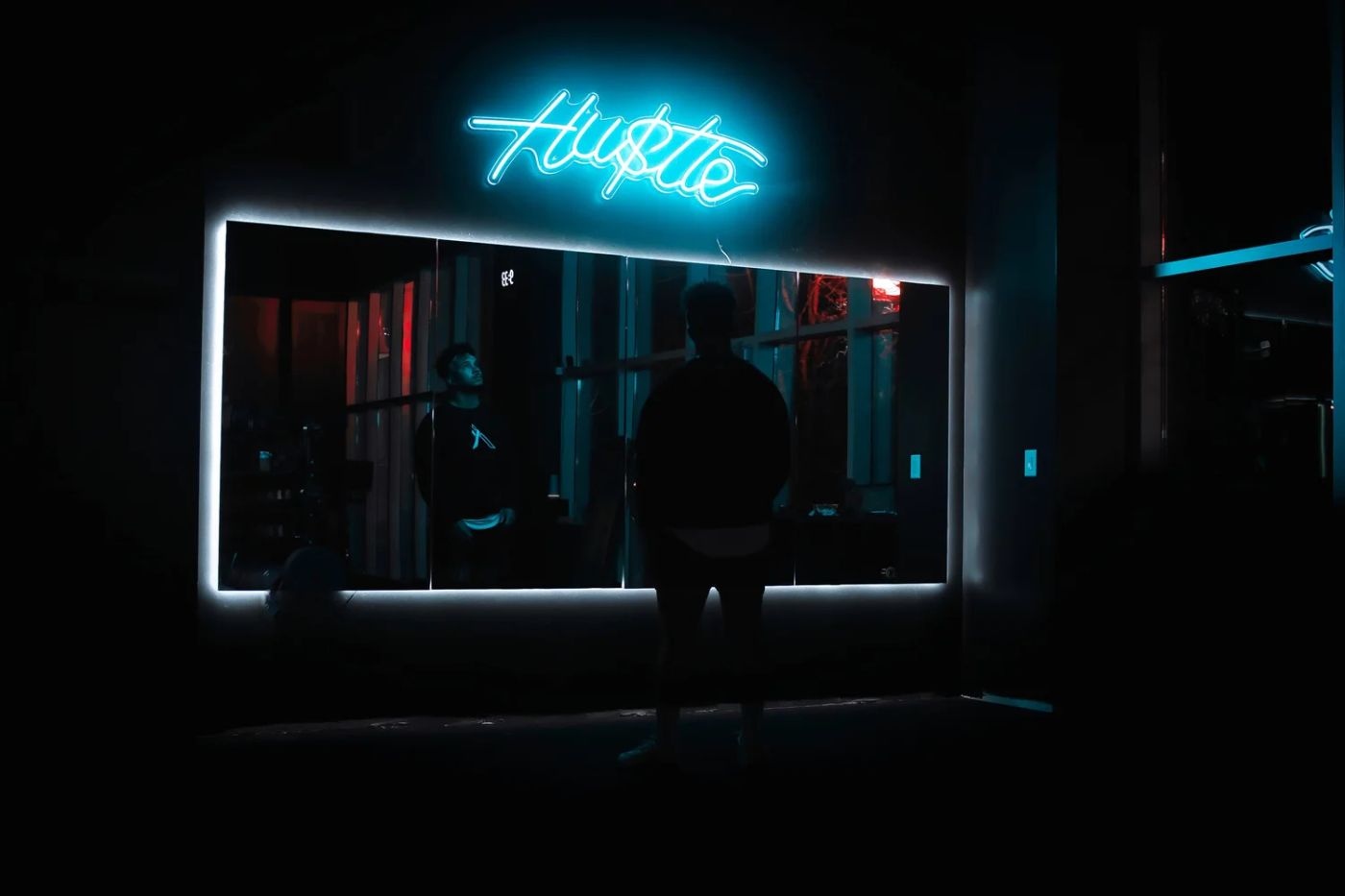 The Hustle neon sign and mirrors inside Inertia Fitness Co.